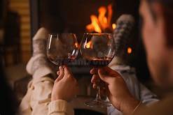 relaxing with a glass of wine by the fire